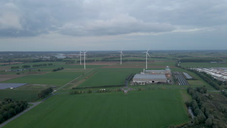 Aerial-of-group-of-spinning-windturbines-in-beautiful-dutch-landscape