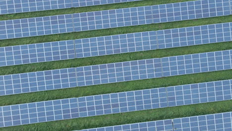 Top-down-aerial-of-rows-of-solar-panels-on-a-green-field