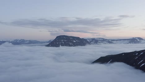 Dreamlike-scenery-with-stratus-clouds-covering-fjord-in-Iceland,-aerial