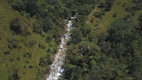 Drone-aerial-view-of-river-with-rocks-in-the-middle-of-the-forest-in-Medellin,-Colombia