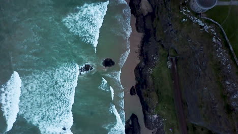Aerial-shot-of-Mussenden-Temple-located-on-cliffs-near-Castlerock-in-County-Londonderry,-high-above-the-Atlantic-Ocean-of-Northern-Ireland