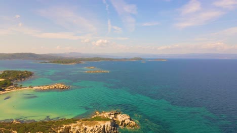 Slowly-forward-moving-aerial-drone-clip-over-an-exotic-beach-in-Vourvourou,-Chalkidiki,-Greece