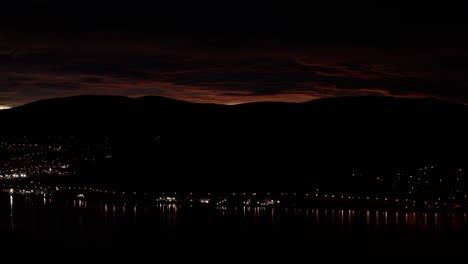 Sonnenuntergang-In-Neuseeland-In-Einem-Berg-Mit-Fernem-Bergstadtlicht-Und-Rotem-Himmel