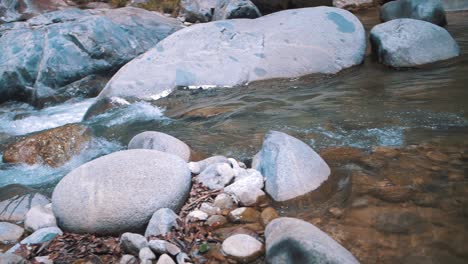 Slow-motion-close-up-shot-of-clear-water-flowing-through-the-calm-river