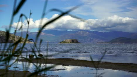 Hermosa-Isla-Aislada-De-Maligrad-Rodeada-Por-El-Agua-Del-Lago-Prespa-En-Las-Montañas-De-Los-Balcanes