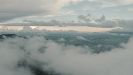 Schöne-Landschaftsdrohnenluftaufnahme,-Fliegen-über-Wolken,-Bergspitze-In-Einem-Nebelwald