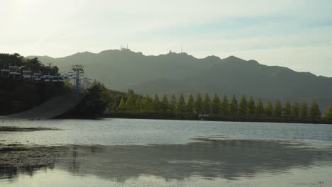 Der-Wunderbare-Fluss,-Der-Sich-Friedlich-Im-Seoul-Grand-Park-Unter-Dem-Hellen-Bewölkten-Himmel-Im-Herbst-Bewegt,-Umgeben-Von-Grünen-Bäumen-Und-Hohen-Bergen---Weitwinkelaufnahme