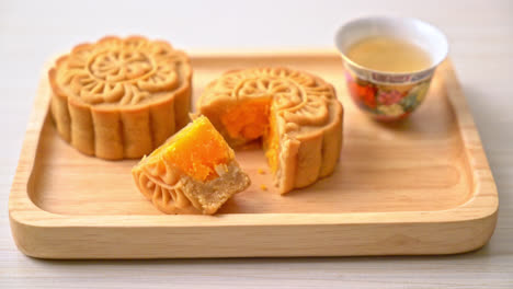 Chinesischer-Mondkuchen-Durian--Und-Eigelbgeschmack-Mit-Tee-Auf-Holzplatte