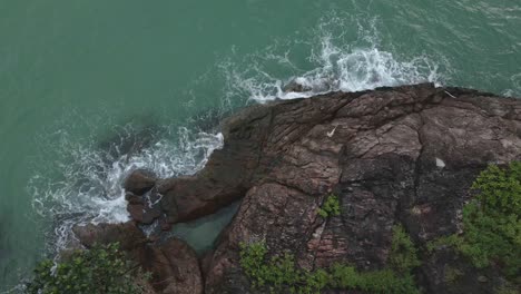 birds-eye-view-drone-shot-of-tropical-coastline-with-granite-rock-and-ocean-and-green-foliage