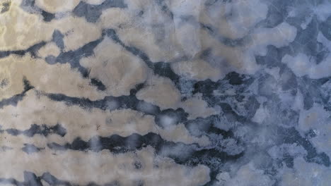 Luftdrohnenaufnahme-Von-Wunderschönen-Formationen-Auf-Einem-Eisbedeckten-See