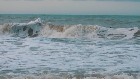 curvy,-foamy-waves-crashing-on-the-shore-of-the-beach-in-slow-motion