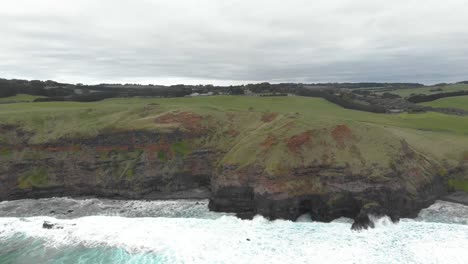 aerial-shot-moving-backwards-away-from-big-ocean-cliffs-out-into-the-sea