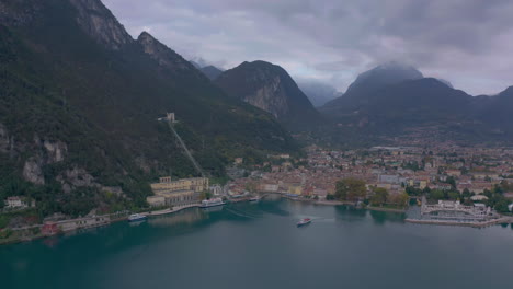 Slow-dolly-out-shot-following-a-passenger-boat-making-it's-way-down-Lake-Garda,-Italy