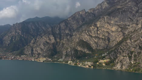 Dolly-in-aerial-shot-flying-towards-a-dramatic,-moody-mountainous-landscape-near-Lake-Garda