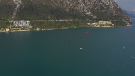 Three-colorful-kiteboarders-having-lots-of-in-the-windy-waters-of-Lake-Garda,-Italy