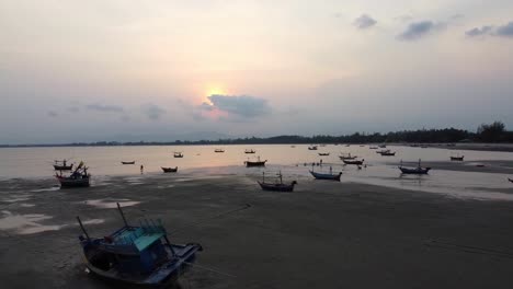 AERIAL:-Asian-style-Fishing-Boats-stranded-at-low-tide-on-the-coast-at-Sunset
