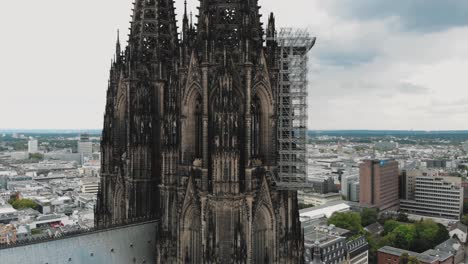4k-Aerial-footage-circling-the-historical-Cologne-Cathedral-during-it's-renovation-construction-in-Cologne,-Germany