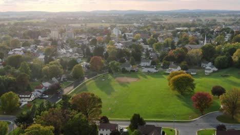Aerial-of-baseball-field,-diamond-in-center-of-small-town-community-neighborhood-homes