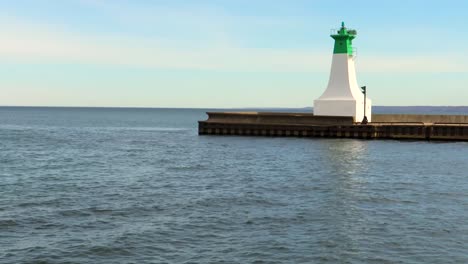 A-green-and-white-lighthouse-on-a-calm,-sunny-day