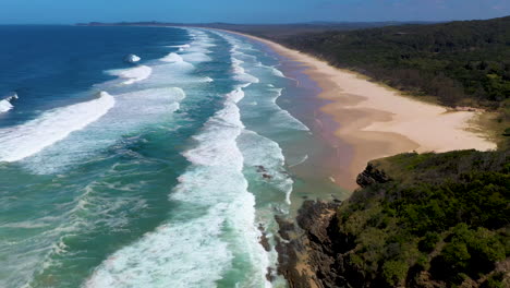 Wide-cinematic-drone-shot-of-ocean-and-island-at-Broken-Head-beach-in-Australia