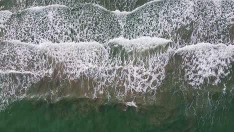 Aerial:-Top-Down-Shot-Of-Long-Ocean-waves-reaching-the-shore-in-Southern-Thailand