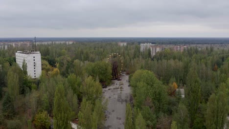 Volando-Sobre-El-Parque-De-Atracciones-Desierto-En-Pripyat,-Ucrania-Con-Vista-De-La-Rueda-De-La-Fortuna-Oxidada---Desastre-De-Chernobyl---Drone-Aéreo