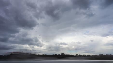 Time-lapse-of-slow-moving-clouds-above-the-river-before-the-storm