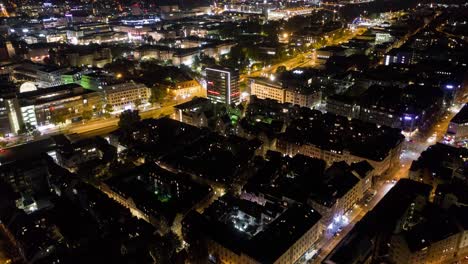 Aerial-night-time-lapse-in-4k-of-downtown-city-skyline-in-Stuttgart,-Germany-panning-down