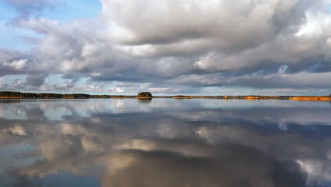 Sea-water-mirrors-distant-islands-in-fall-in-Scandinavia,-slow-pan