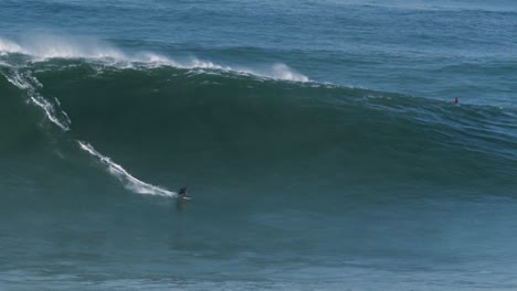 Cámara-Lenta-De-Un-Surfista-De-Grandes-Olas-Montando-Una-Ola-Monstruosa-En-Nazaré,-Portugal