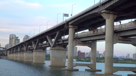 U-Bahn-Zug,-Der-Die-Cheongdam-Brücke-über-Den-Han-Fluss-Bei-Sonnenuntergang-In-Seoul,-Südkorea,-überquert---Low-Winkel-Weitwinkelaufnahme,-Statische-Aufnahme