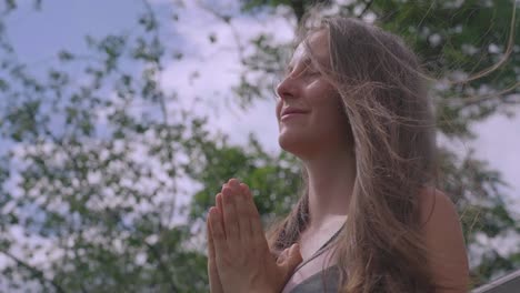 Close-shot-of-a-woman-in-a-meditation-pose-in-nature