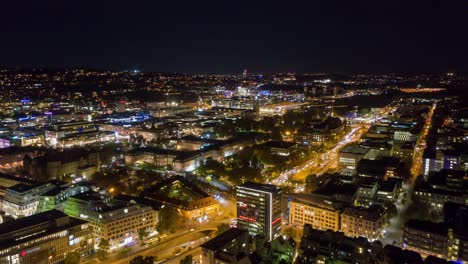 Moving-aerial-night-time-lapse-in-4k-of-downtown-skyline-in-the-city-of-Stuttgart,-Germany-from-left-to-right