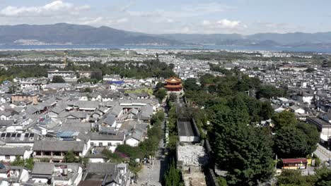 Dali-walled-old-town-and-watchtower-in-modern-Chinese-city,-aerial