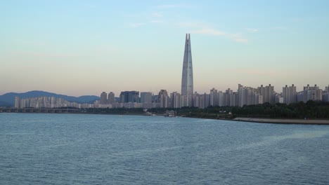 Puente-Jamsil-Y-Torre-Lotte-Al-Atardecer,-Seúl,-Corea-Del-Sur,-Frente-Al-Río-Han