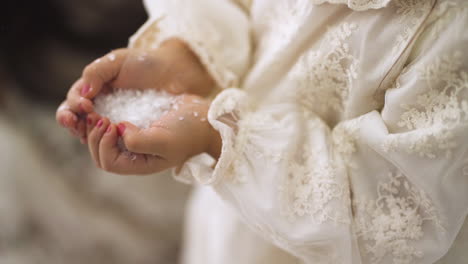 Slow-motion-of-Young-little-girl-holding-fake-Christmas-snow-in-between-her-hands---High-angle-close-up-shot