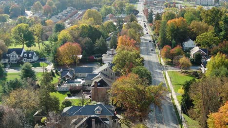 Reverse-dolly-shot-above-street-in-residential-community-neighborhood-in-Northeast-USA-during-autumn