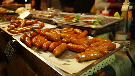 Asian-Night-Street-Food-Market:-Close-up-Footage-of-grilled-Thai-sausages-Displaying