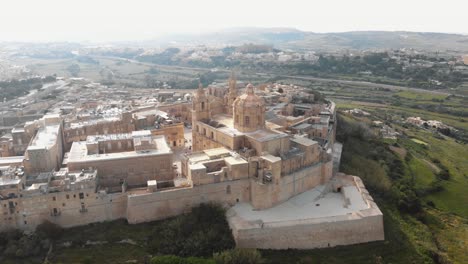 Panoramic-view-outside-the-Mdina-city-fortifications-of-Metropolitan-Cathedral-of-Saint-Paul---Fly-forward-aerial-shot