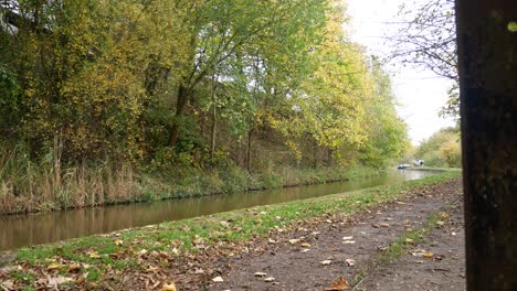 Historic-canal-autumn-golden-leafy-muddy-pathway-quiet-waterway-reflections