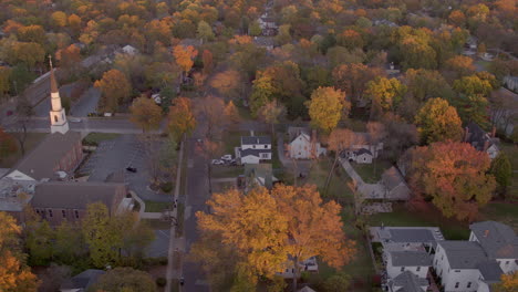 Aerial-pull-down-street-in-Kirkwood,-Missouri-neighborhood-in-Autumn-at-golden-hour,-first-half-of-two-clips