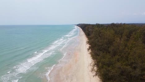 Aerial-time-lapse-side-view-of-Long-Ocean-waves-reach-the-shore-in-Southern-Thailand