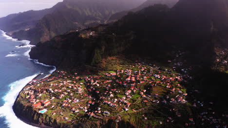 Hermosa-Toma-Aérea-De-Un-Pequeño-Pueblo-Ubicado-Junto-A-La-Costa-De-La-Isla-De-Madeira