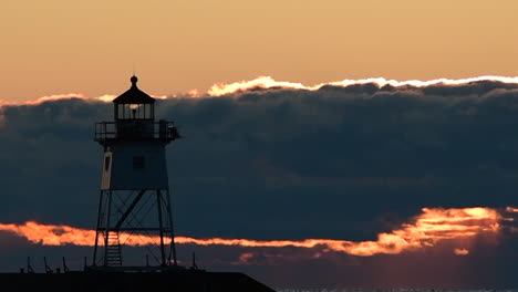 Lighthouse-flashing-at-sunset-on-Lake-Superior-in-Grand-Marais,-Minnesota