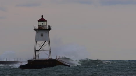 Waves-crashing-a-lighthouse-in-Grand-Marais,-Minnesota-during-storm-in-slow-motion