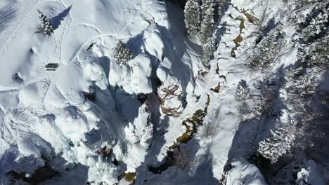 Aerial-view-of-Ouray-Ice-Park,-southwestern-Colorado,-snow-capped-cliffs,-frozen-waterfalls,-area-for-climbing-and-hiking,-bridseye-drone-shot
