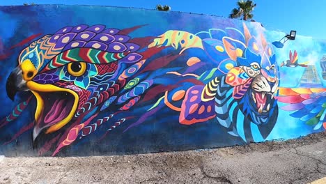 Pan-down-the-colorful-wall-art-in-the-Mayan-style-decorates-the-walls-of-a-building-Rocky-Point,-Mexico,-Puerto-Peñasco,-Gulf-of-California,-Pacific-Ocean
