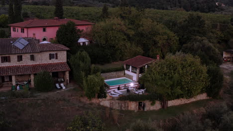 Drone-panning-around-beautiful-resort-in-Florence,-few-houses-and-a-pool-in-the-middle-of-nature