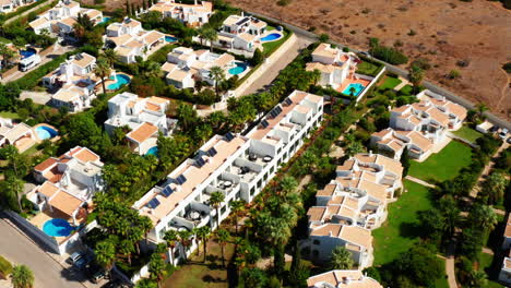 Aerial-top-down-of-luxury-hotel-resort-apartments-with-private-swimming-pool-during-sunny-day,-Algarve-Portugal