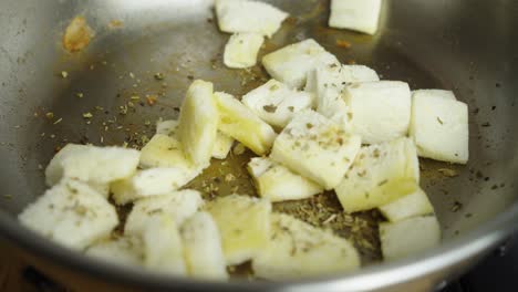 Adding-spices-and-frying-bread-pieces-for-Caesar-salad-inside-frying-pan